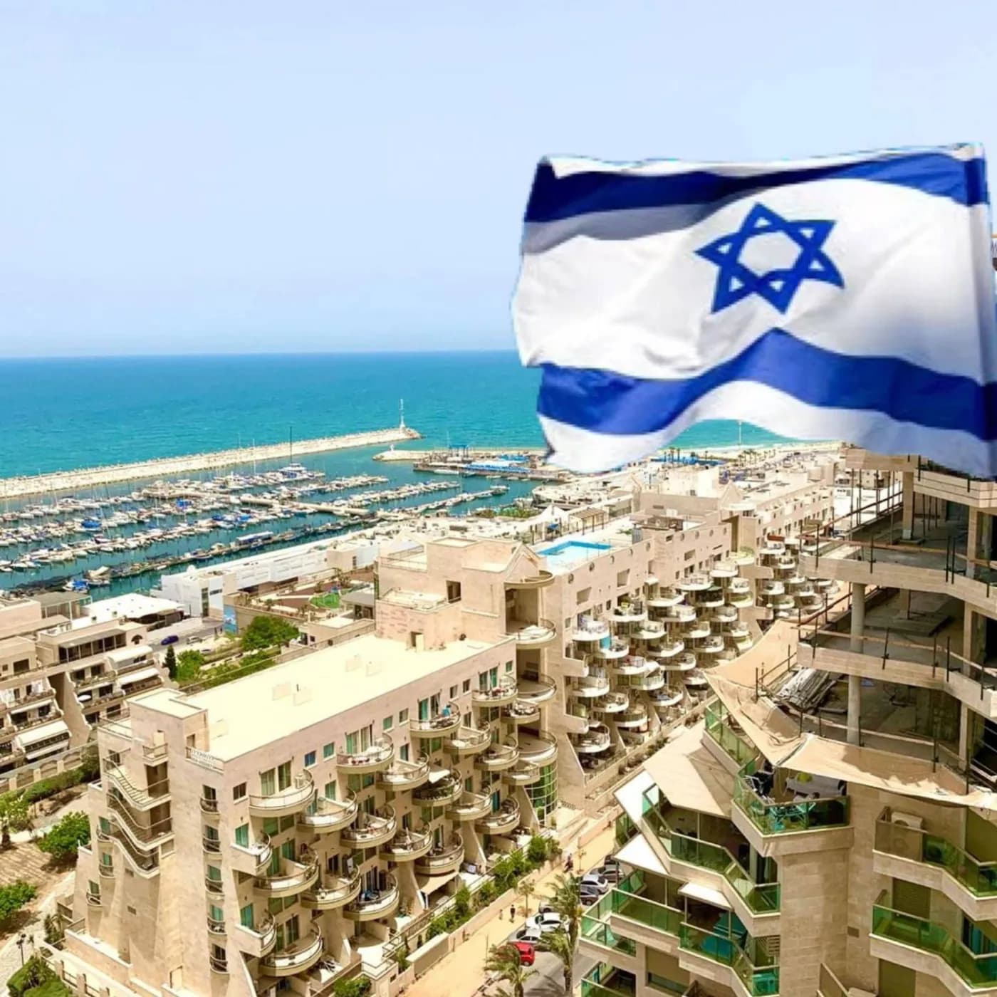 Флаг Израиля на фоне ашкелонской марины, яхт и жилых кварталов у моря
